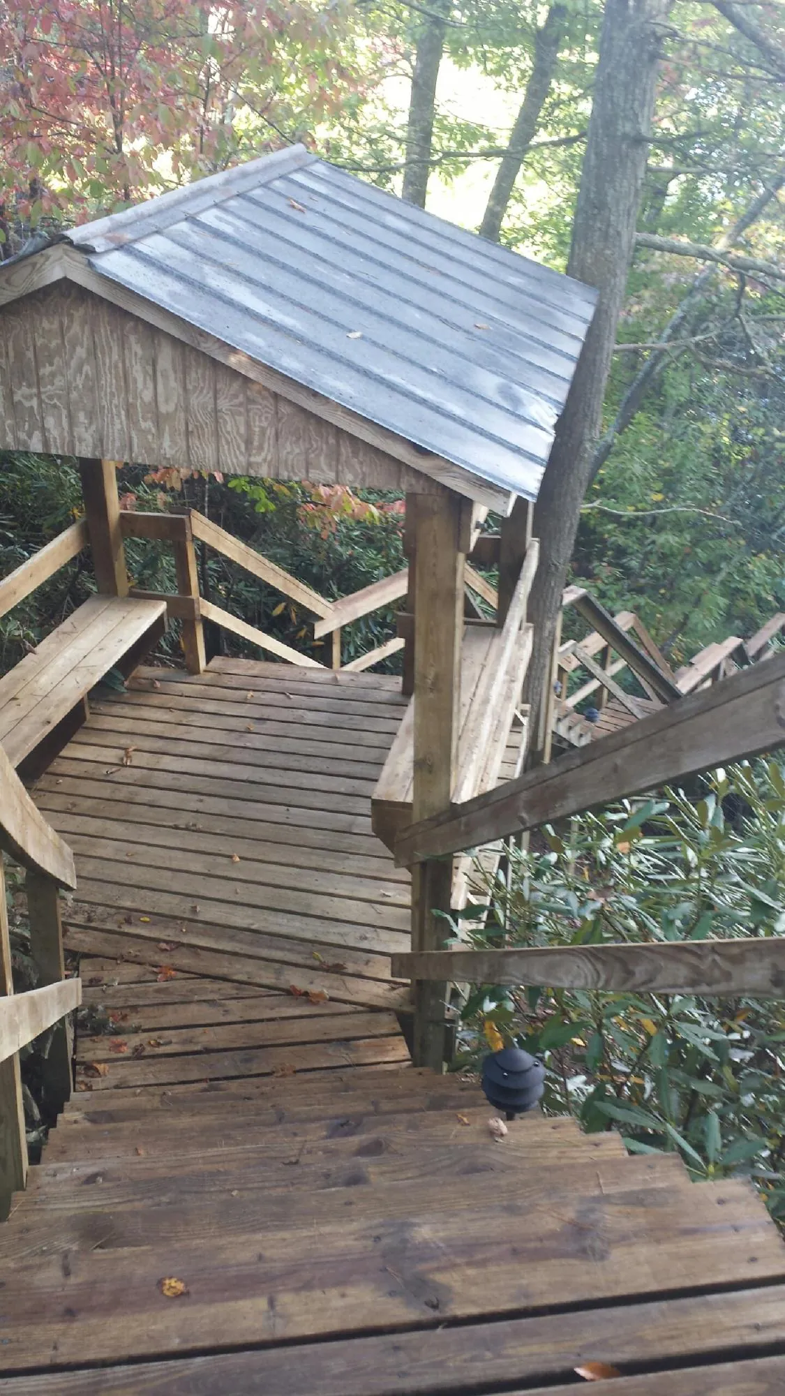 Metal roofed shelter over wooden steps on a wooded walkway — Skylight Repair & Installation work by our crew in Enon
