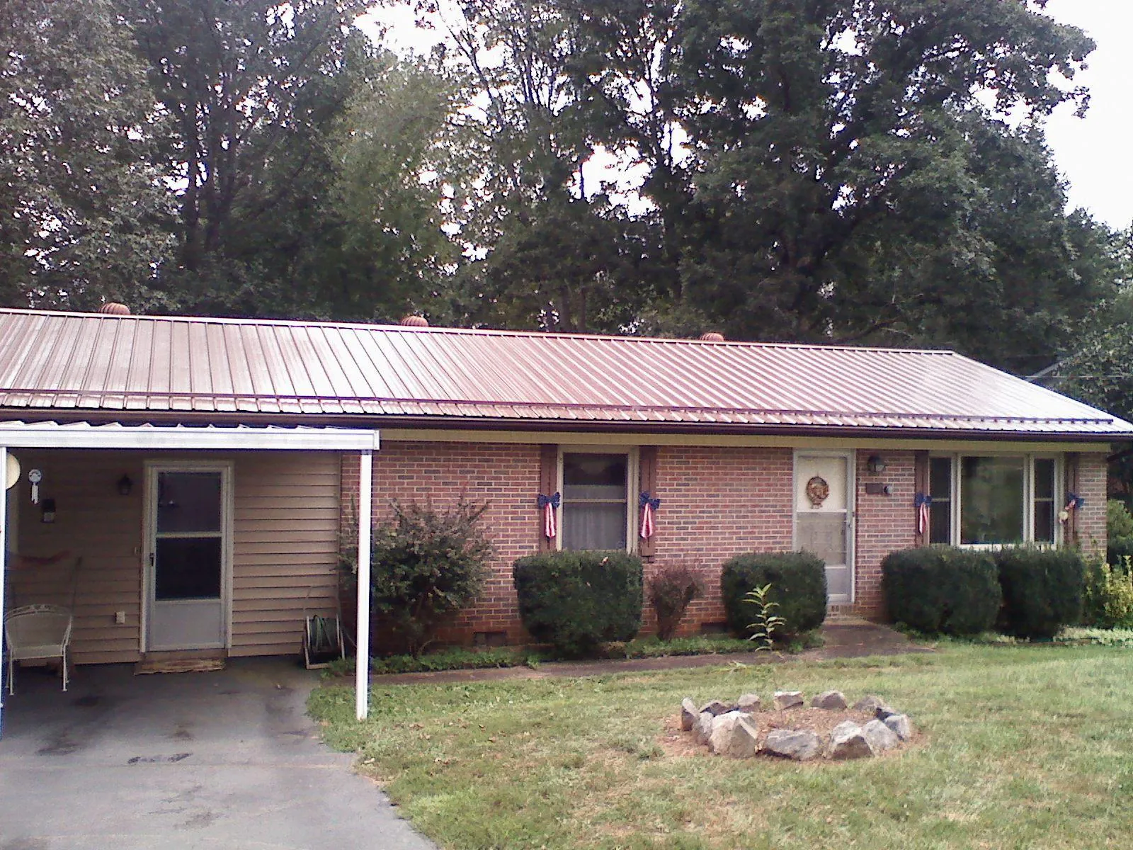 Bronze metal roof and carport on a brick ranch home — Roof Repair work by our crew in Enon