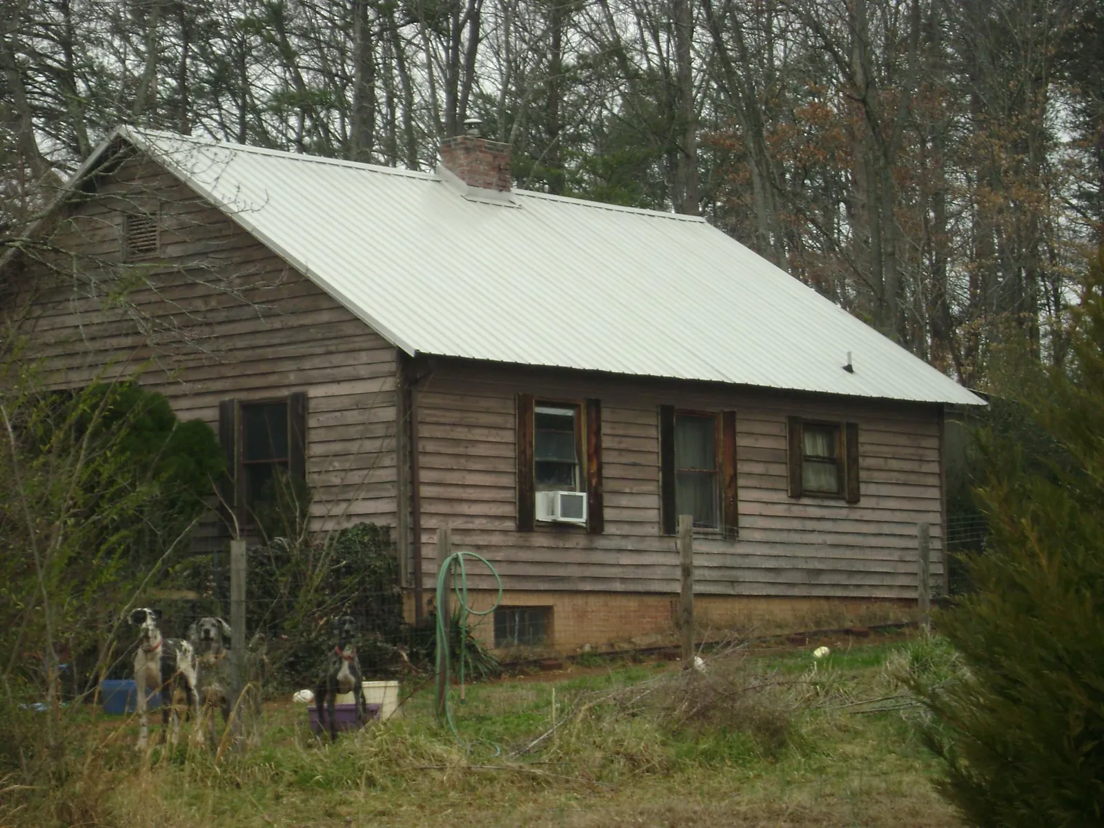 White metal roof on an old wood sided farmhouse, from a Metal Roof Installation job in Enon
